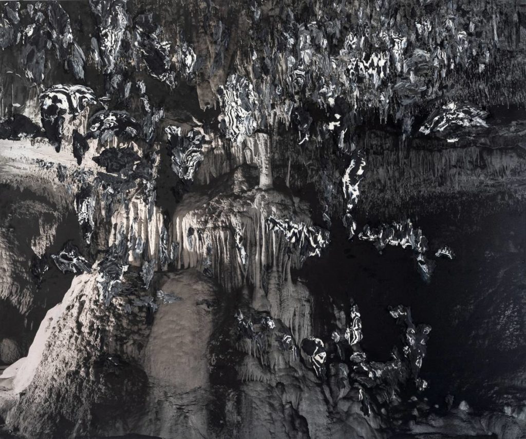 Il s'agit d'un tableau d'Emmanuel Rivière. L'artiste a maculé un fond photographique de grotte avec de la pâte à modeler noire et blanche.